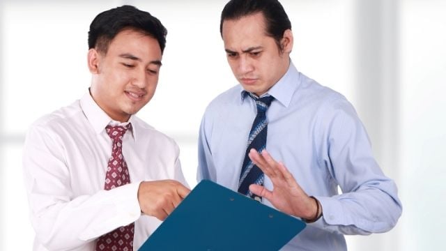 two men talking with a board